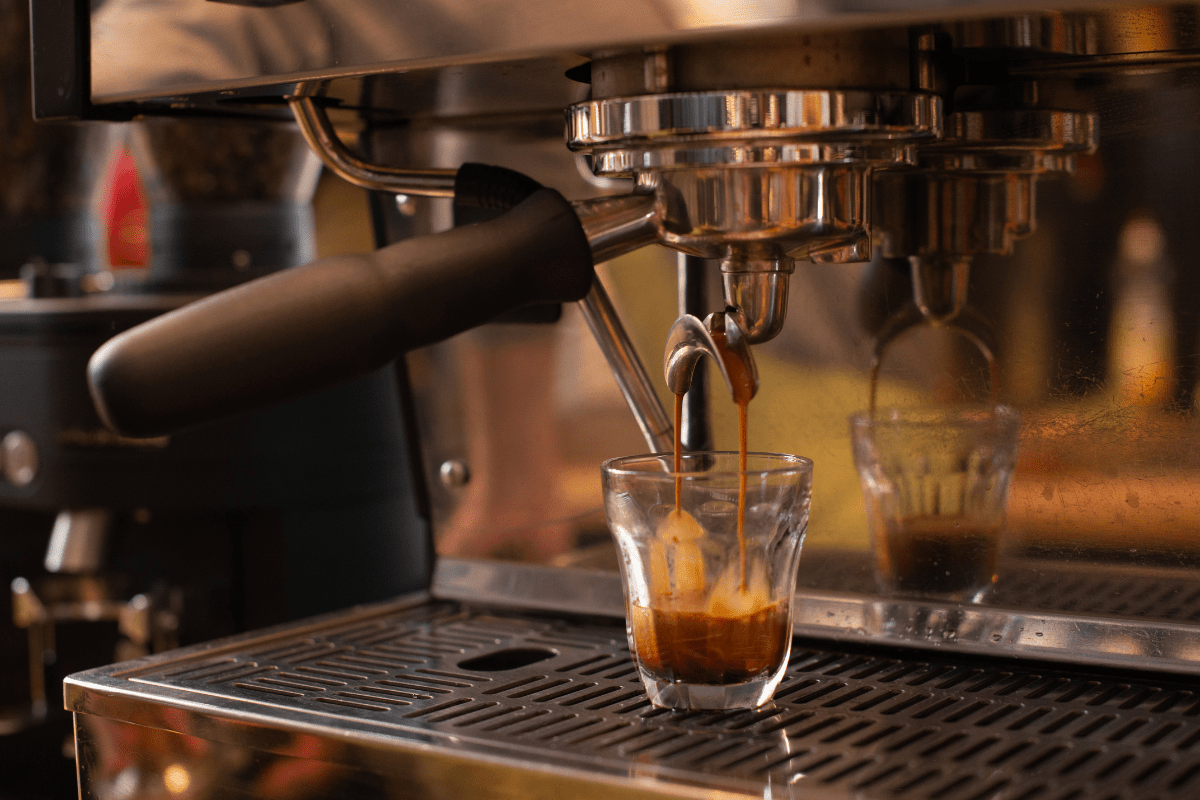 espresso machine dropping shot of espresso into glass cup