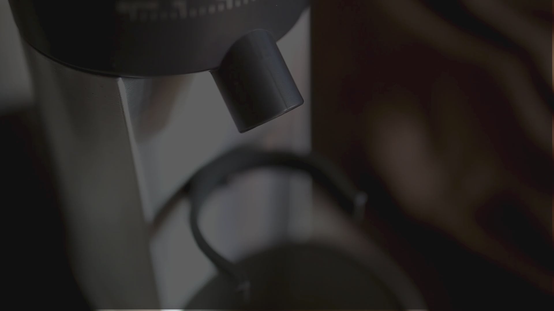 Load video: Burr coffee grinder dosing grounds into portafilter for home espresso